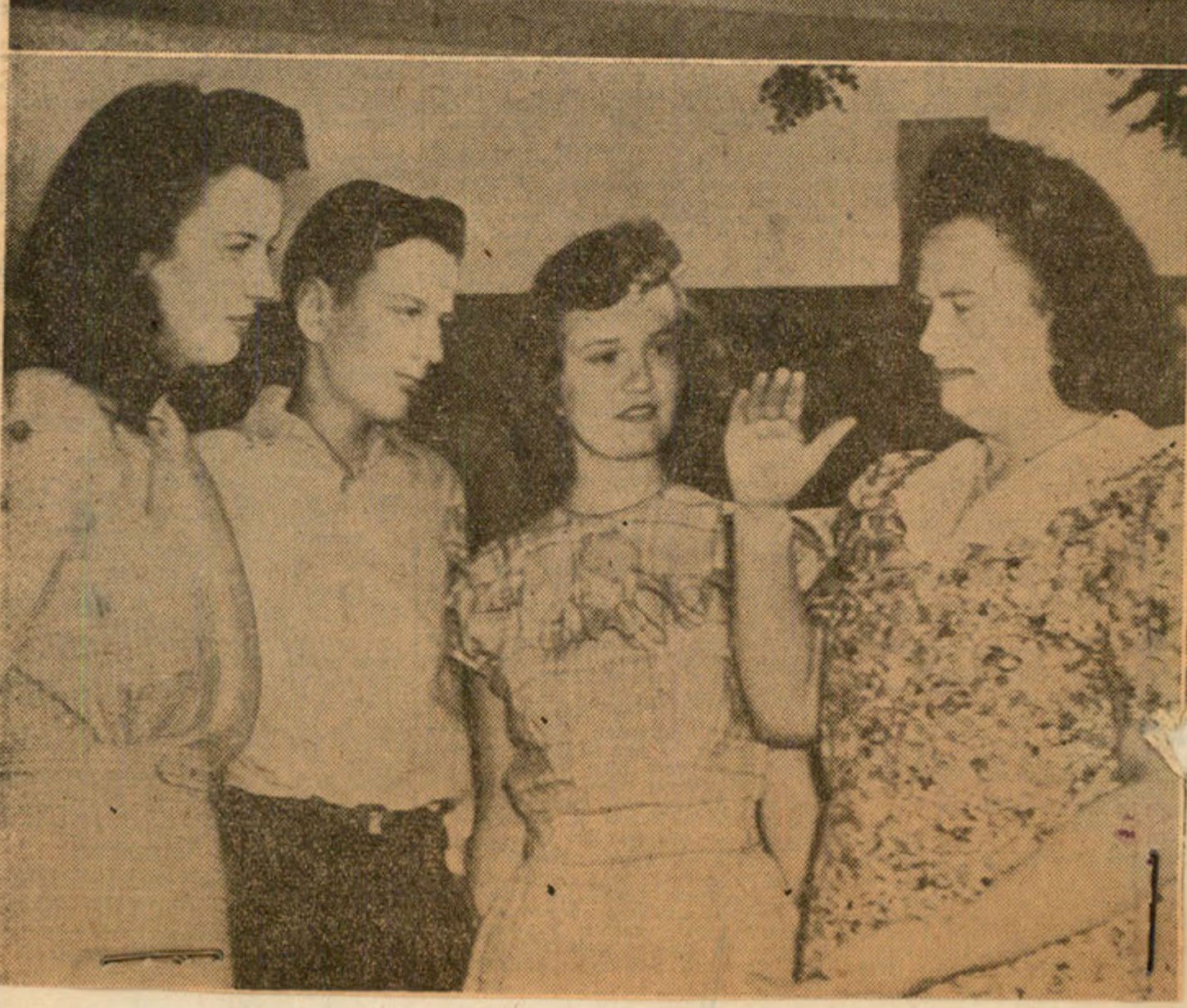 A group of four people (one man, three women) appear to be in conversation.
