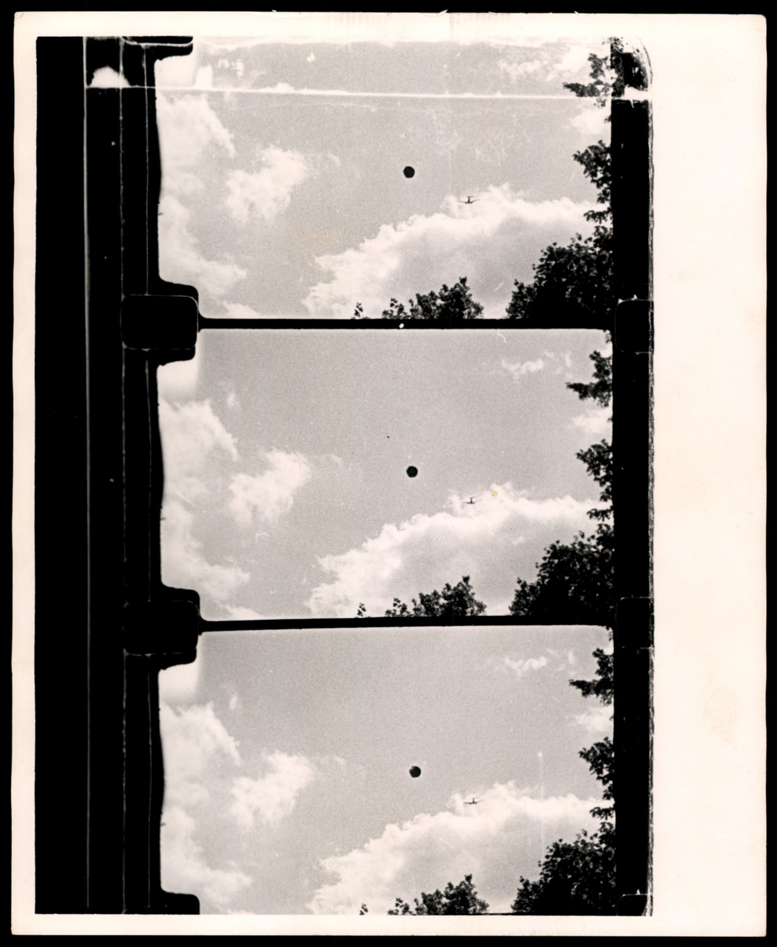 Three consecutive frames from a film strip showing a dark circular object and a conventional aircraft.